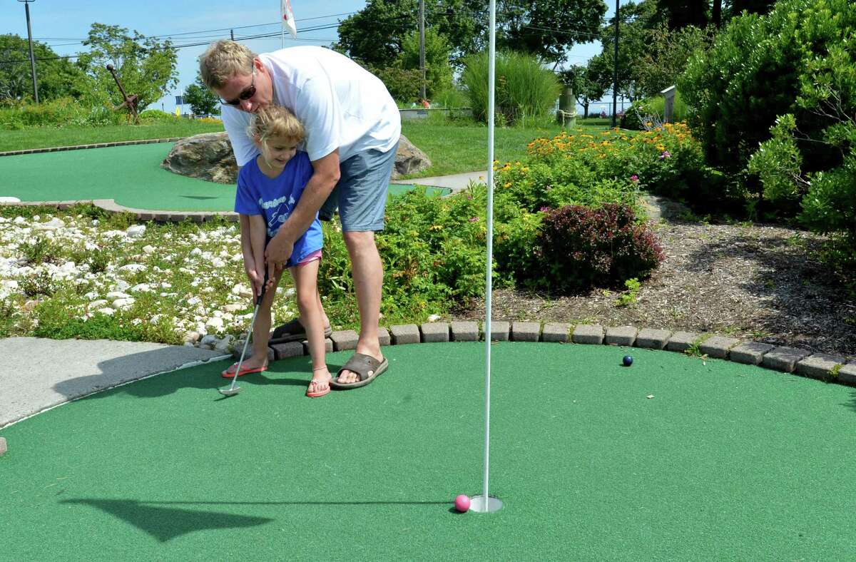 Patrick Casciolo and daughter Emily play a game of Mini Golf at the Norwalk Cove Marina Mini Golf on a recent sunny afternoon