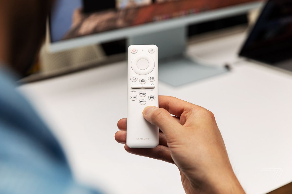 A closeup of the slim remote that comes with the M8. It’s white and has a scroll ring at the top, plus buttons for power, mic input, media control, and four dedicated streaming app buttons.