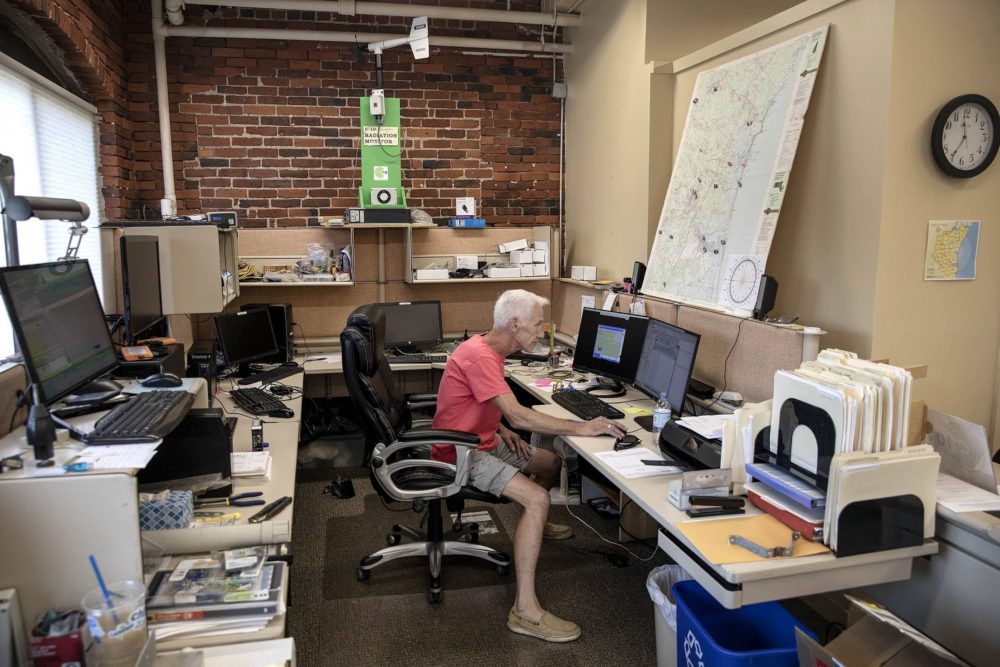 Network administrator Mike Mansir, surrounded by monitoring equipment at C-10's office in Amesbury, Mass. (Robin Lubbock/WBUR)