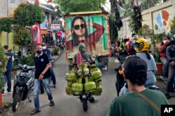 People make their way through a crowded street in Jakarta, Indonesia, in this Saturday, Feb 5, 2022 iPhone photo, taken by Dita Alangkara. (AP Photo/Dita Alangkara)