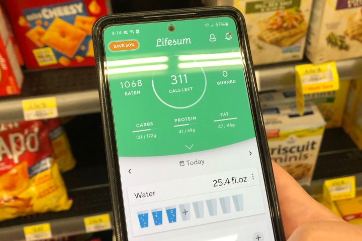 LifeSum app on screen of phone with crackers in the background on a store shelf.