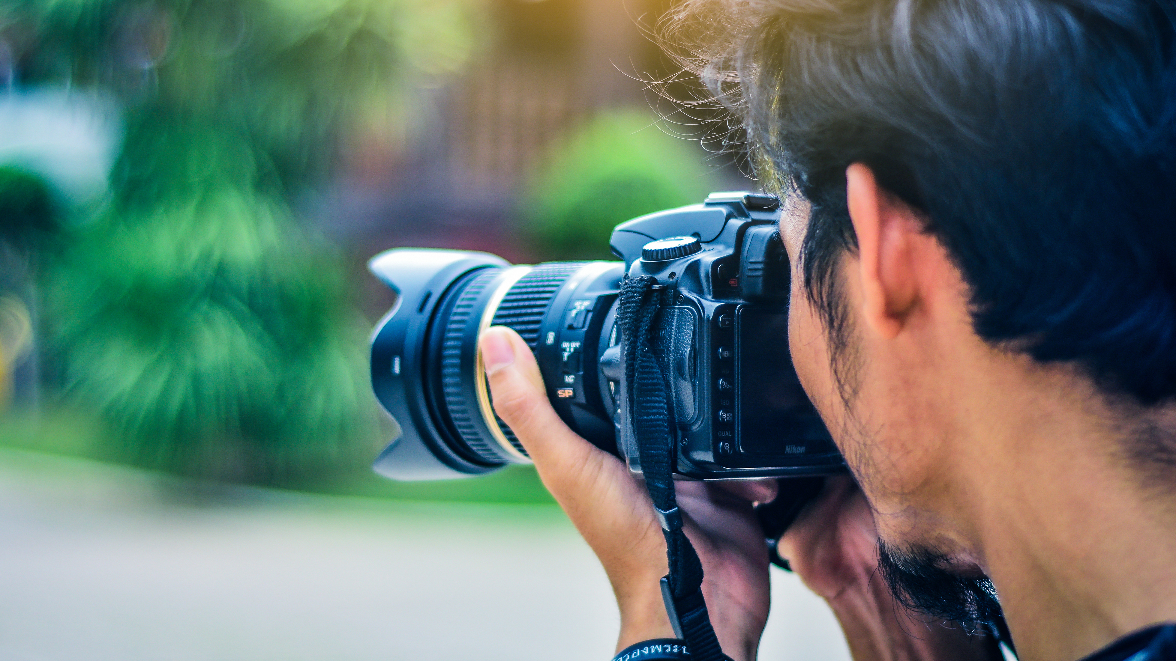 A man holding a DSLR to his eye