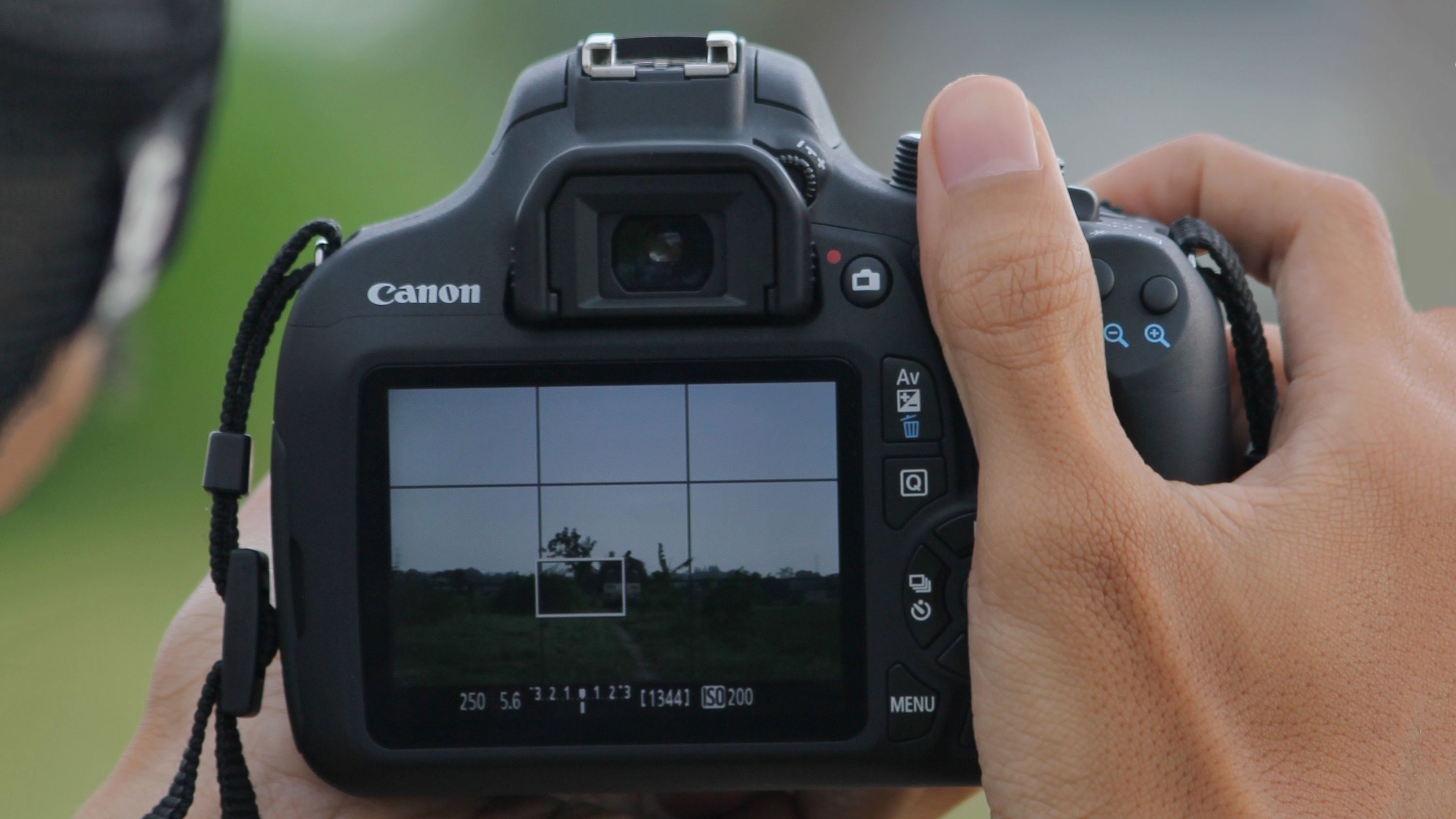 Two hands holding up a DSLR camera